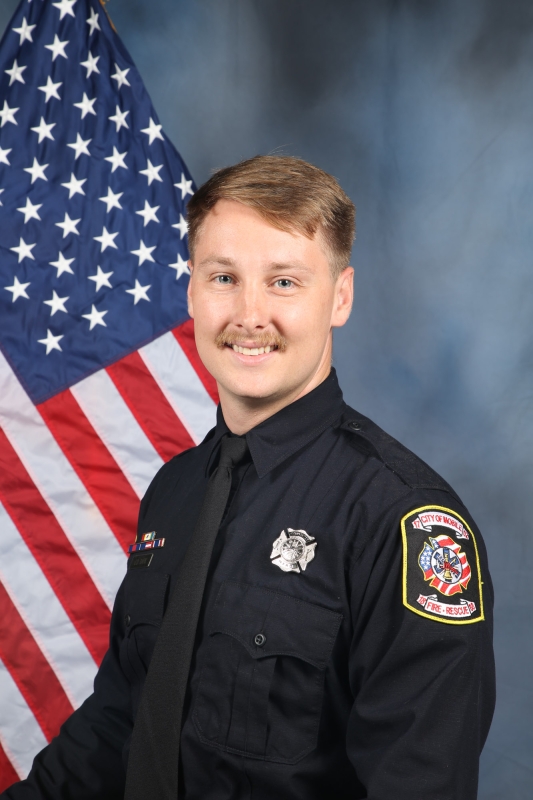 Firefighter Jason Bark in front of American flag