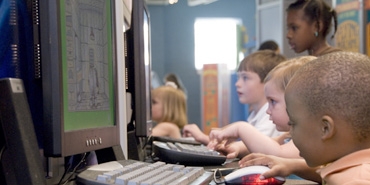 young students sitting in view of computer screen